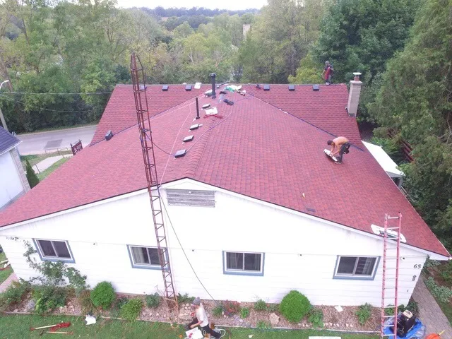 Aerial view of a red-shingle re-roof in progress