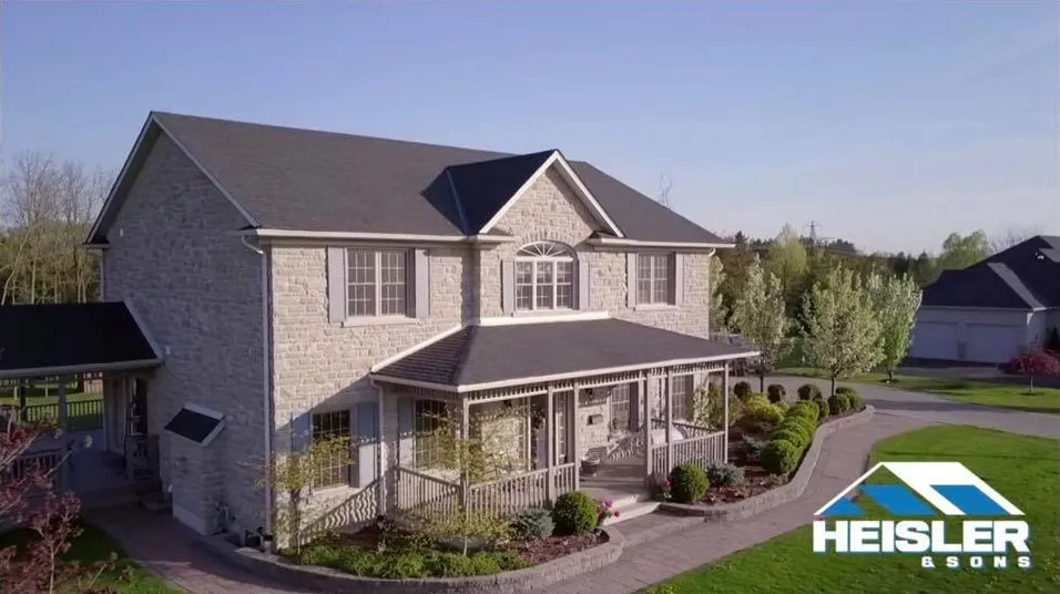 Stone house with a new dark shingle roof